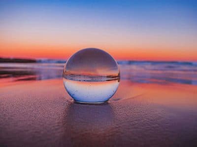 Crystal ball on beach at sunset